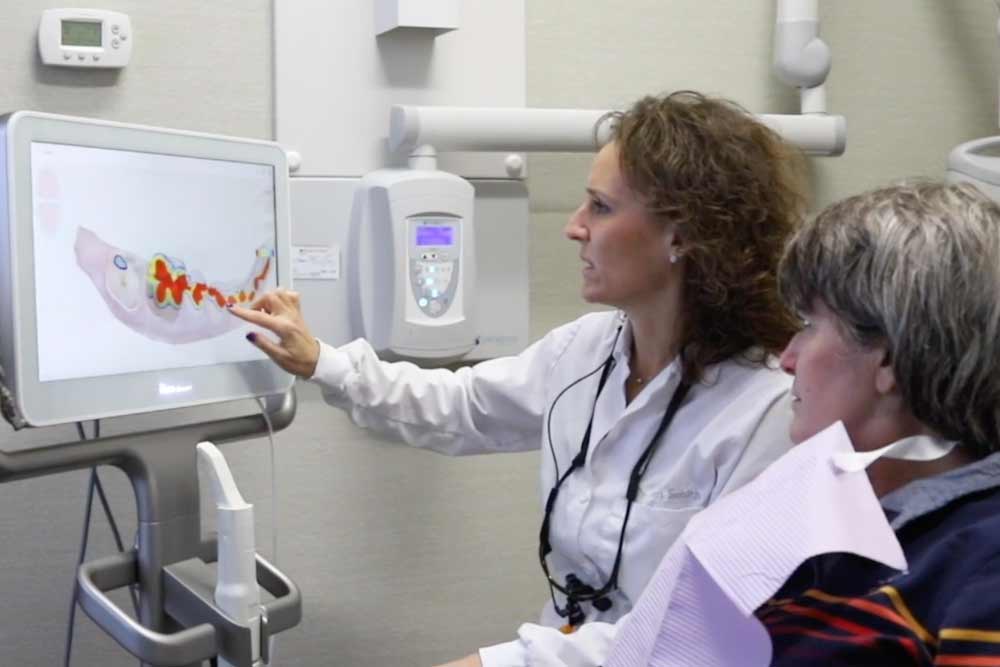 Dr. Heidi smith showing digital x-rays to a patient